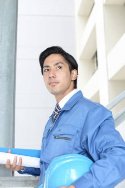 Mavi üniformalı gülümseyen Asyalı işçi