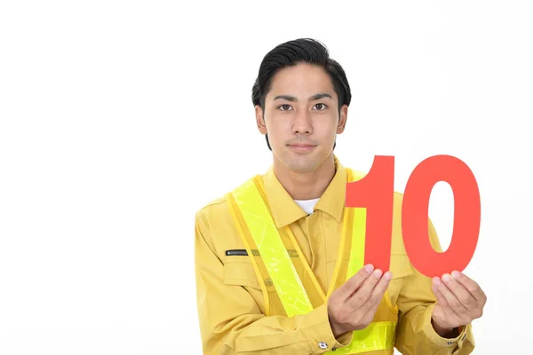Lächelnder Asiatischer Arbeiter Mit Einer Nummer — Stockfoto