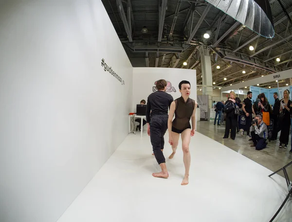 モスクワ、ロシア - 2019年4月11日:厳格な黒い衣装を着た正体不明のバレエダンサーが、2019年4月11日にロシア・モスクワで開催されるPhotoforum 2019トレードショー&展示会で、グドセン社のブースでパフォーマンスを行います。 — ストック写真