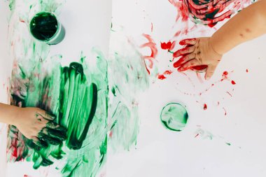 2-3 yıl yaşlı çocuklar çıplak elleriyle beyaz kağıda elleriyle boya onlar yeşil kullanarak, kırmızı ve mavi renk beyaz bez kağıt.