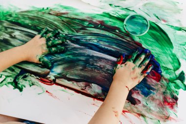 2-3 yıl yaşlı çocuklar çıplak elleriyle beyaz kağıda elleriyle boya onlar yeşil kullanarak, kırmızı ve mavi renk beyaz bez kağıt.