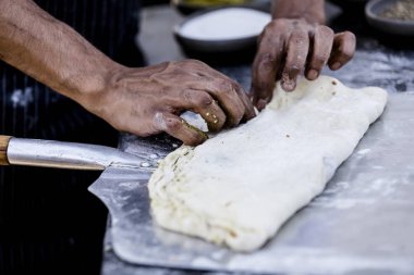 Her türlü her türlü fesleğen, susam ve diğerleri gibi bitkiler bulunan taze ekmek yapma. İnsan eli yüzü gösterilir