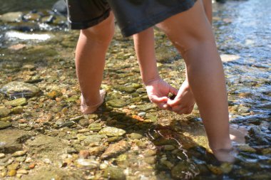 Yaz günlerinde bir nehir taşlarla oynayan küçük çocuk