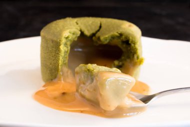 Matcha yeşil çay erimiş lav kek beyaz bir plaka üzerinde