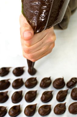 Kadın el çikolata Truffles Againts beyaz arka plan hazırlanıyor