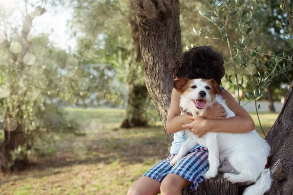 Dziecko przytulanie psa w parku. Bezwarunkowa koncepcja miłości. — Zdjęcie stockowe