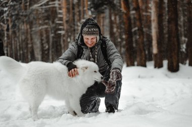people playing with funny dog in winter forest 