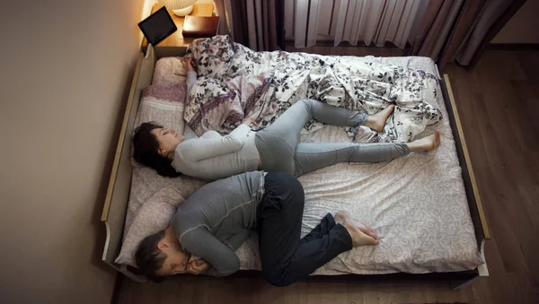 The woman pull a blanket on the bed Young adult couple sleeping peacefully on the bed in bedroom.