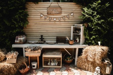 Düğün Ziyafet süslemeleri. Ahşap rustik tarzda dekor. Tatlılar, atıştırmalıklar, kekler, böğürtlen ve patlamış mısır ile şenlikli tablo. Resepsiyonlar Tarlets. Çiçekler ve yeşillikler ile ahşaptan yapılmış süslemeleri. Düğün büfesi 