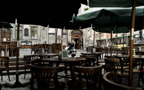 Mobiletle gezen güneş gözlüklü genç ve güzel kızlar. Eski şehir merkezinde motosiklet süren güzel kadınların portresi. Yaz tatili. Siyah tişörtlü kızlar klasik scooterlı