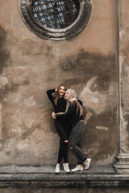 Eski Avrupa şehrinde çekici kadın turistler. Eski taş evin yanında duran güzel genç kızlar. Şık gençler seyahat ve Lviv, Ukrayna yaz saati zevk. Siyah kızlar yaz zevk