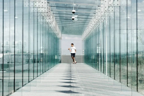 Young man walking inside the modern building in high-tech architecture style. Fashion man walking through modern building hall