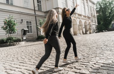 Mutlu arkadaşlar şehir merkezinde yürürken eğleniyorlar. Güzel genç pozitif kızlar yaz tatillerini geçirirler. İki gülümseyen güzel gençler eski harika Avrupa şehri etrafında seyahat. Ortak tatil konsepti