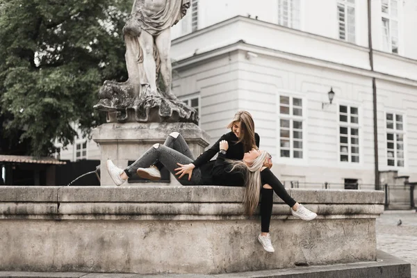 Deux Belles Filles Assises Fontaine Amis Portant Des Vêtements Noirs — Photo