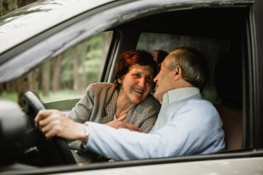 Modern araba içinde mutlu yaşlı çift. Yaşlılar arabada birlikte seyahat ediyorlar. Smiled ve aktif emekliler yeni araba içinde tarih ve romantizm sahip. Mutlu yaşlı aile konsepti