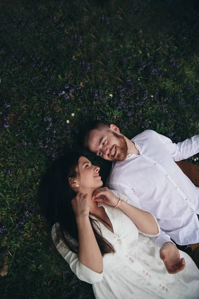 Yeşil çimenlerin üzerinde yatan mutlu bir çift. Erkek arkadaşı ve kız arkadaşı şefkatle birbirlerine bakıyor ve bir çayırda rahatlatıcı. Doğada romantik bir tarih. Genç çift parkta gün zevk