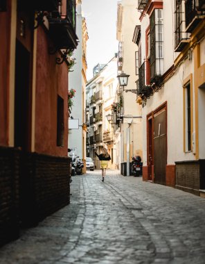Sarı elbiseli genç güzel kadının yaz açık hava portresi. Neşeli sarışın kız eski taş evler arasında yürüyor. Portekiz'de tatil in tadını çıkarıyorum. Seyahat ve aktif yaşam tarzı konsepti