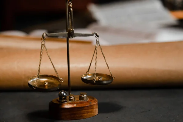 Küçük şeyleri tartmak için eski gojd terazileri. Hukukun sembolü ve adalet terazisi karanlık masada. Antika terazi renginde, ağırlıkları vintage iç mekanı olan bir oda. Kapatın..