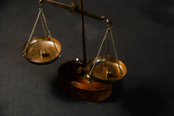 Старые весы Gojd для взвешивания мелочей. Символ закона и шкалы правосудия на черном столе. Антикварная Весы с весами в комнате с винтажным интерьером. Вид сверху
