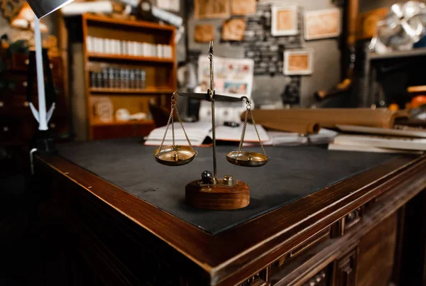 Küçük şeyleri tartmak için eski gojd terazileri. Hukukun sembolü ve adalet terazisi karanlık masada. Antika terazi renginde, ağırlıkları vintage iç mekanı olan bir oda. Kapatın..