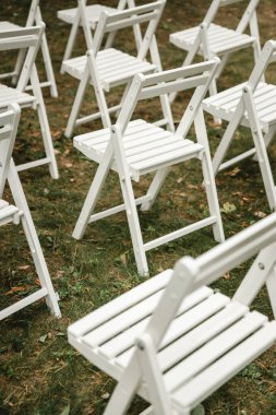 Çimlerin üzerinde duran düğün sandalyeleri. Beyaz