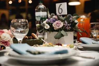 Düğün masasının güzel dekorasyonları. Seremoni üzerine çiçek kompozisyonları. Çiçeklerle ve yeşilliklerle süslenmiş ahşap süsler. Kırsal tarzda. Kapat.