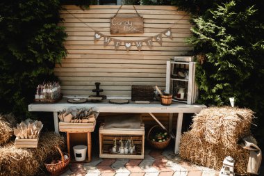 Düğün ahşabı süslemesi. Kaba bir ziyafet. Çiçeklerle, yeşillikle ve salon alanıyla süslenmiş ahşap tahta. Düğün fotoğrafı bölgesi. Parti alanı kırsal tarzı.