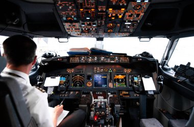 Pilot kabininden görüntü. Kontrol paneli. Tarlaların ve köyün üzerinde uçak uçuran bir pilota yaklaş. Gösterge panelinde çok sayıda düğme, navigasyon aygıtı