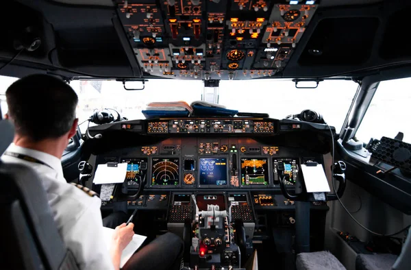 View from pilot's cabin. Control panel. Close up of a pilot flying airplane over the fields and village. Many buttons, navigation devices on dashboar