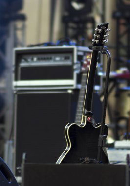 Sahne Alanı'nda elektro gitar ayakta raf. Arka planda odak amplifikatör dışında olduğunu