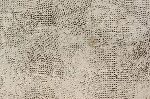 小さな丸い穴に覆われた未完成の壁テクスチャ — ストック写真
