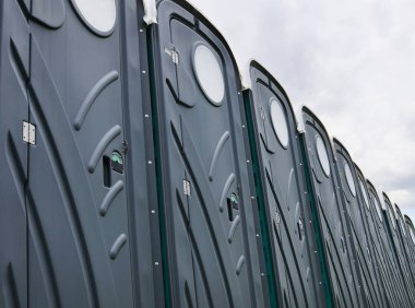 Satır, plastik taşınabilir tuvalet bulutlu gökyüzü karşı