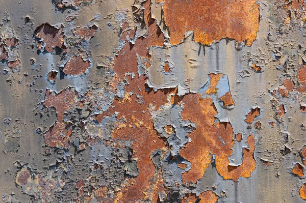 Old, rusty, rough metal texture covered in patches of peeling off old paint