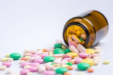 Çeşitli ilaç tıp hap, tablet beyaz bir arka plan üzerinde cam şişede. Metin için yer kopyalayın