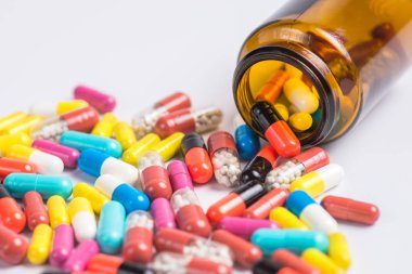 Tabletler ve beyaz zemin üzerine cam şişe hap