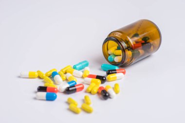 Çeşitli hap, tablet beyaz bir arka plan üzerinde cam şişede