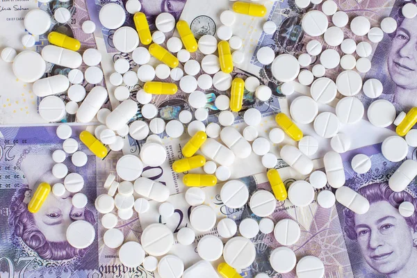 White and yellow pills on a money background.