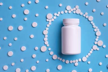 Hap, tablet ve şişe mavi zemin üzerine beyaz. Metin için yer kopyalayın