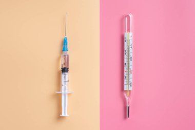 Mercury termometre ve şırınga pembe bir arka plan üzerinde. Metin için yer kopyalayın