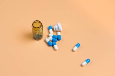 Cam şişe turuncu zemin üzerine mavi hap. Metin için yer kopyalayın