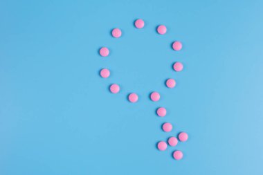 Kadının simgesi mavi bir arka plan üzerinde pembe hap oluşur