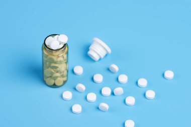 İlaç tıp hapları, beyaz hap turuncu bir arka plan üzerinde cam şişede çeşitli. Metin için yer kopyalayın