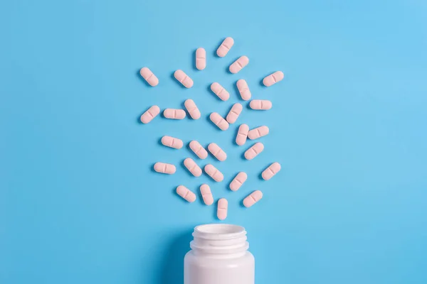 Pastillas Rosadas Tabletas Frasco Blanco Sobre Fondo Azul Copiar Espacio — Foto de Stock