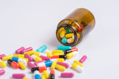Çeşitli ilaç tıp hap, tablet beyaz bir arka plan üzerinde cam şişede