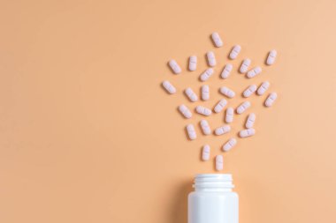 Pembe hap, Tablet ve Sarı zemin üzerine beyaz şişe. Metin için yer kopyalayın