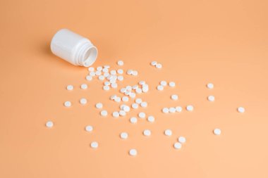 Beyaz hap, Tablet ve turuncu zemin üzerine beyaz şişe. Metin için yer kopyalayın