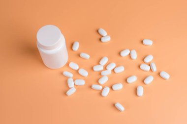 Beyaz hap, Tablet ve turuncu zemin üzerine beyaz şişe