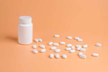 Beyaz hap, Tablet ve turuncu zemin üzerine beyaz şişe