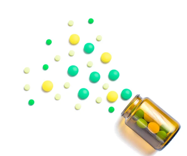 Tabletter i brun glasflaska på vit bakgrund — Stockfoto