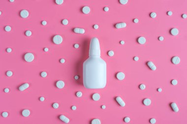Beyaz hap ve pembe bir arka plan üzerinde beyaz şişe. Kopya alanı için 